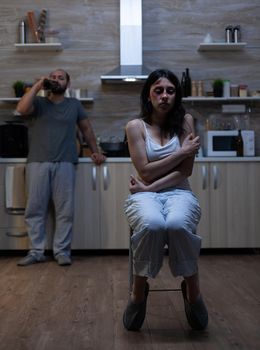 Abused bruised woman being terrified of violent man having alcohol addiction and anger issues. Couple with domestic violence problems, aggression, fighting and depression