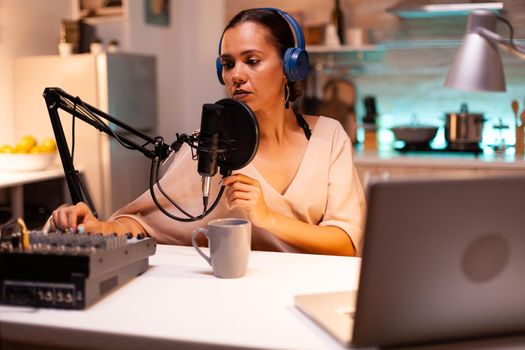 Influencer wearing headphones recording new podcast series for her audience. On-air online production internet broadcast show host streaming live content, recording digital social media communication
