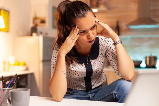 Woman doing difficult online computer work feeling headache during night time. Employee using modern technology at midnight doing overtime for job, business, career, network, lifestyle ,wireless.