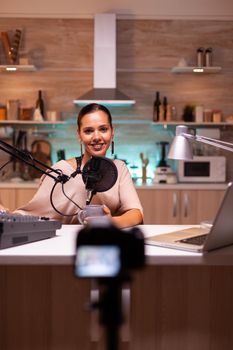 Vlogger on air during her online show using mixer and professional microphone. Online show production internet broadcast host streaming live content, recording digital social media communication