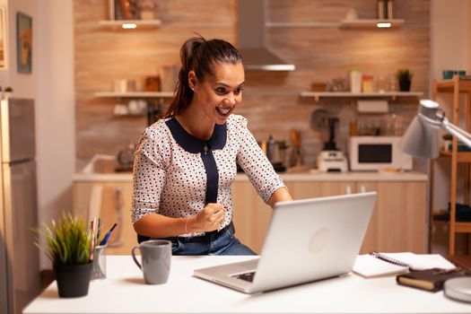 Excited businesswoman after receiving good news on eamil working late at night in home. Employee using modern technology at midnight doing overtime for job, business, busy, career, network, lifestyle.