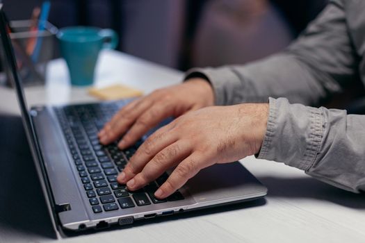 Hands of office manager over keypad in corporate workplace. Close up of male hands typing on laptop keyboard in office. Business, working from home, studying online concept