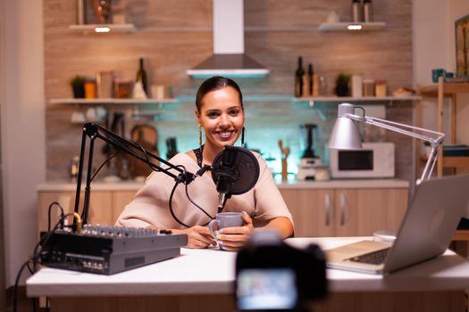 Blogger looking at camera while recording video and speaking on microphone. Online show On-air production internet broadcast host streaming live content, recording digital social media communication