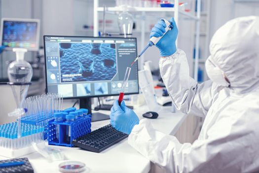 Medical engineer using dispenser to take sample of blood from test tube in lab. Doctor working with various bacteria and tissue, pharmaceutical research for antibiotics against covid19.