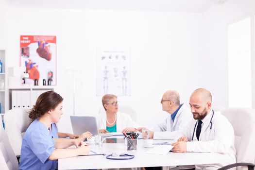 Medical team interacting at a meeting in conference room during discussion about health. Clinic expert therapist talking with colleagues about disease, medicine professional