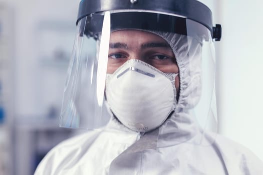 Close up of wearied chemist in laboratory wearing ppe equipment during mondial outbreak with covid19. Overworked researcher dressed in protective suit against invection with coronavirus during global epidemic.