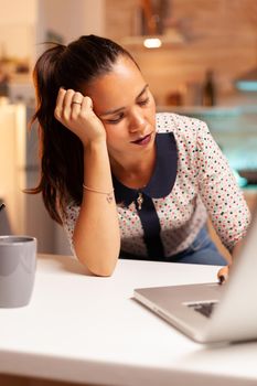 Woman keeping eyes closed because of exhaustion while working on a project for work late at night. Employee using modern technology at midnight doing overtime for job, business, busy, career, network.