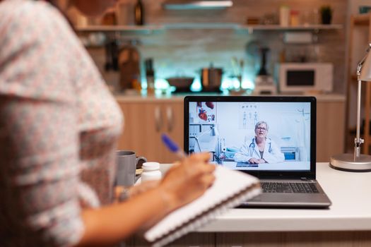 Doctor explaining diagnosis during a video conference with patient at midnight. Physician giving consultation to sick patient from hospital office during virtual examination, screen, medicine, appointment.