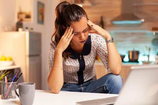 Stressed woman working overtime feels eye fatique after computer work late at night. Employee using modern technology at midnight doing overtime for job, business, busy, career, network, lifestyle.