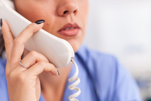 Medical receptionist answering phone calls from patient in hospital. Female nurse, doctor having a phone conversation with sick person during consultation, medicine.