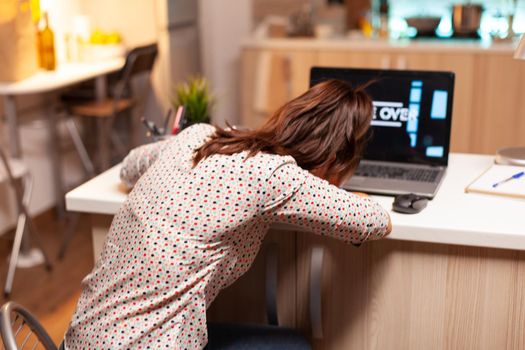 Sad woman because she lost on computer games during night time in home kitchen. Professional gamer playing online videop games on her personal computer. Geek cyber e-sport.