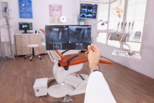 Radiologist man doctor holding teeth jaw diagnosis radiography planning healthcare treatment for patient. Specialist orthodontist working in stomatology dentistry hospital office room