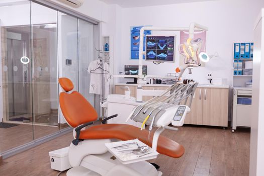 Interior of modern professional equipped dental healthcare office with teeth x ray on monitor, dentistry orthodontic workplace. Medical stomatology cabinet for teethcare, medical tooth heath treatment