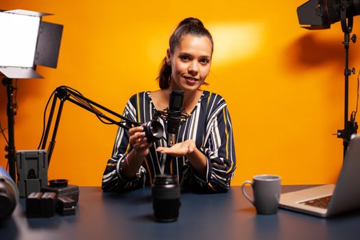 Woman testing vlog equipment in professional home studio. New media star influencer on social media talking video photo equipment for online internet web show.