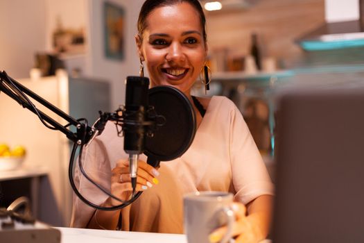 Woman recording sound in home studio for podcast. Creative online show presenter, video, sound production station in home , lifestyle night, web, internet, media equipment, laptop.
