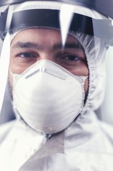 Close up of virus scientist wearing ppe equipment in microbiology laboratory during covid19. Overworked researcher dressed in protective suit against invection with coronavirus during global epidemic.