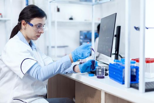 Young scientist loads pipette with sample for dna examination in plastic test tube. Chemistry researchr in sterile laboratory using modern technology to test microbiology liquid.