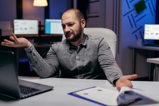 Stressed entrepreneur looking confused at laptop in the course of overworking. Confused businessman while doing overtime to finish a big project for company.