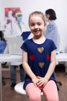 Child at medical examination in hospital office during global pandemic. Specialist in medicine providing health care services consultation, radiographic treatment in clinic.