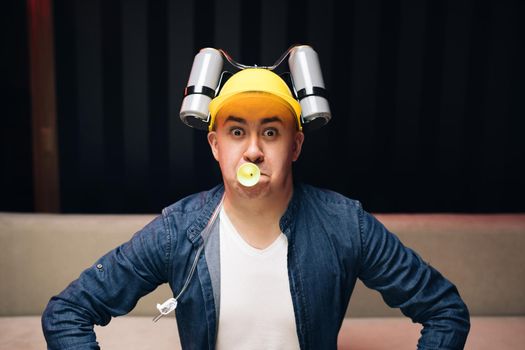 Man with beer helmet on the head sitting on the sofa and watching football. Expressing, screaming and emotion.