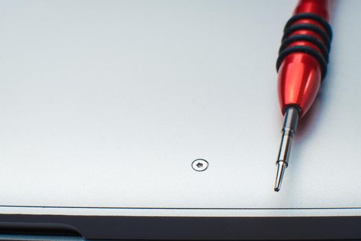 Repair - Screwdriver on the laptop. Close up. Concept of repair or technical service notebook Warranty period.