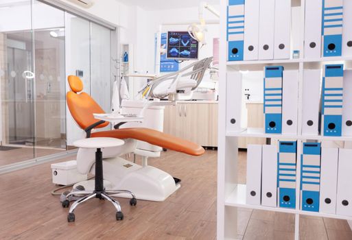 Empty stomatology orthodontic office room with nobody in it equipped with professional medical dental teeth instruments prepared for dentistry health surgery. Cabinet ready for tooth surgery