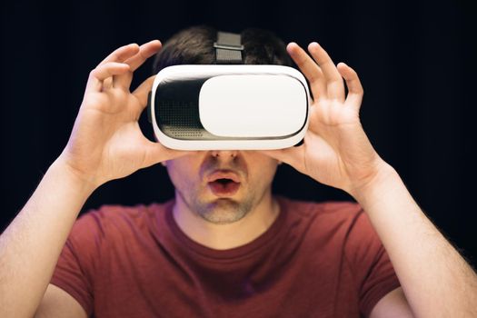 Man using modern 3D vr glasses indoors. Student playing using VR glasses. Handsome man wearing virtual reality headset. Augmented Reality.