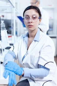 Successful scientist in genetics looking at camera in research laboratory Chemist wearing lab coat using modern technology during scientific experiment in sterile environment.