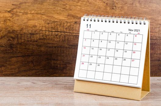 November desk calendar 2021 on wooden background.