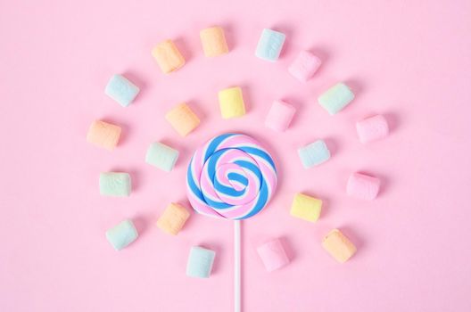 Colorful marshmallows and sweet candy on pink background.