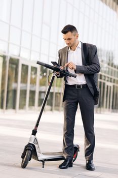 Phone application for rental scooter. Ecological city transport. Businessman rents electric scooter using mobile phone app. Man take electric kick scooter. Tourist taking e-scooter or bicycle.