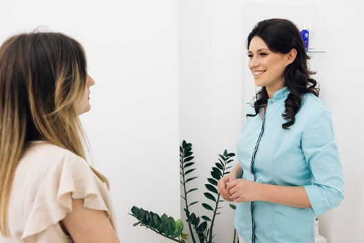 Modern rehabilitation physiotherapy worker with woman client. Female medical assistant wears blue coat talking to patient. Physiotherapy Improves the Patient's Quality of Life.