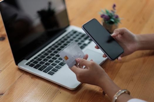 Woman holding credit card and using smartphone at home, businessman shopping online, e-commerce, internet banking, spending money, working from home concept.