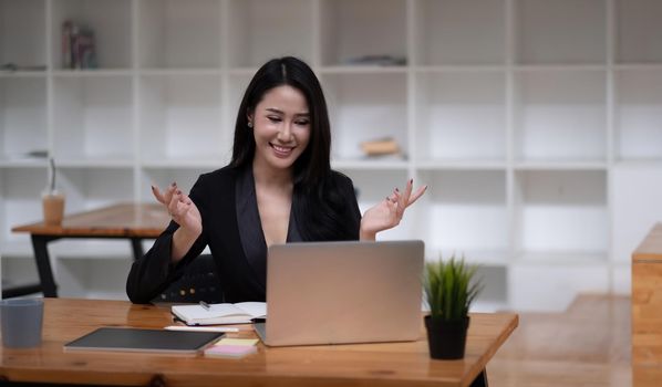 Happy asian woman communicate by video call on computer working from home. Smiling businesswoman talking by video conference, online virtual meeting using computer.