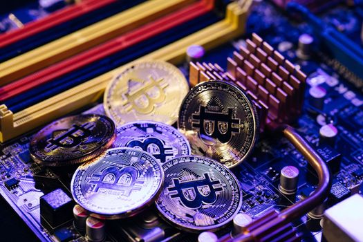 Blockchain technology, bitcoin mining. Close up shot of Bitcoins coins isolated on motherboard background. Crypto currency, bitcoin. BTC, Bit Coin.