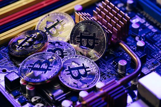 Crypto currency, bitcoin. BTC, Bit Coin. Blockchain technology, bitcoin mining. Close up shot of Bitcoins coins isolated on motherboard background.