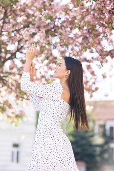 Girl with pink cherry blossom petals in cherry blossom forest