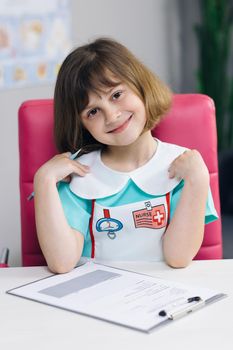 Close up of a little cute girl face wear medical clothing. Face portrait closeup. Beautiful child looking at the camera and smiling. Positive child. Funny little girl smiling looking at camera.