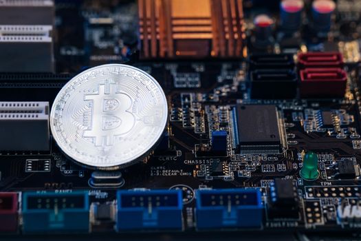 Bitcoin. Crypto currency Silver Bitcoin, BTC, Bit Coin. Macro shot of Bitcoin coins isolated on motherboard background.