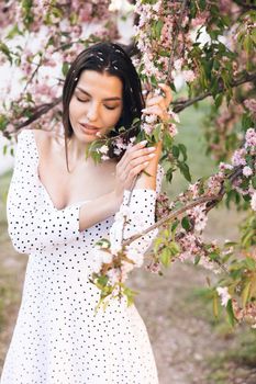 Young woman at sunlight with long hair Fashion model female girl cosmetic beauty confident happy cheerful in cherry blossom forest.