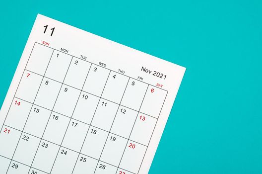 Close up November 2021 calendar sheet on green background.
