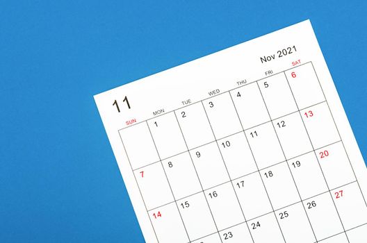 Close up November 2021 calendar sheet on blue background.