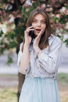 Portrait of happy woman enjoy success on mobile phone. Closeup joyful girl reading good news on phone. Surprised lady celebrating victory on phone.