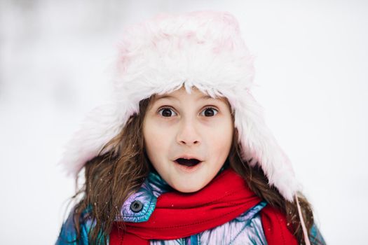 Little girl on face surprised child having fun enjoying winter day. Holidays and celebrations concept. Portrait of joyful Caucasian little cute girl with surprised happy face.