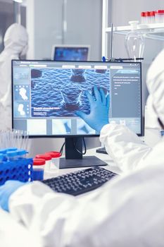 Chemist man looking computer screen working on vaccine against coronnavirus in modern facility. . Lab engineers conducting experiment for vaccine development against covid19 virus