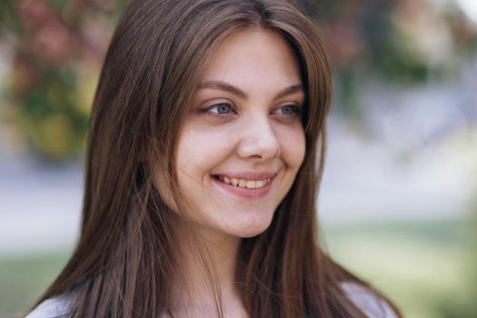 Close-up portrait of young woman face open eyes looking feel happy the day sun is shining and the wind blow. Face of beautiful soft woman with natural make-up