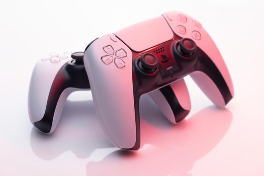 NEW YORK - March 3, 2021: Sony Playstation 5 Dualsense game controller. New product from Sony, wireless white PlayStation 5. White controller in red light