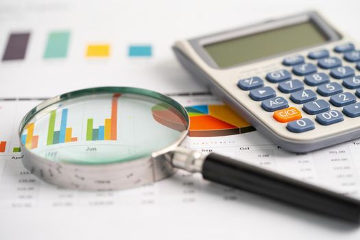 Magnifying glass and calculator on charts graphs paper. Financial development, Banking Account, Statistics, Investment Analytic research data economy, Stock exchange trading, Business office concept.