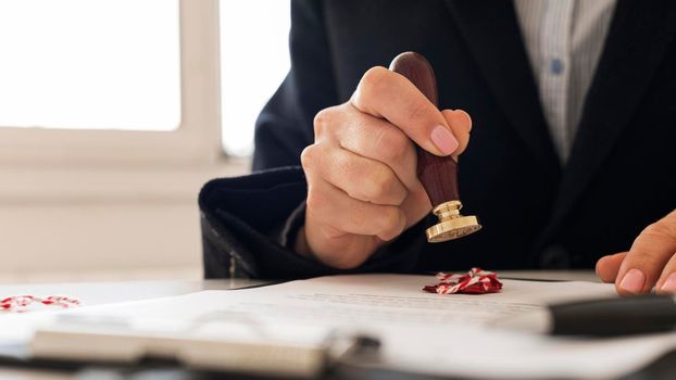 person using wax seal certificate. High resolution photo