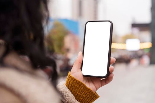 woman holding blank smartphone outside. High resolution photo